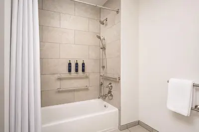 a bathroom with a shower with a white tub and a shower curtain at Martis Valley Lodge, Tapestry Collection by Hilton in Truckee