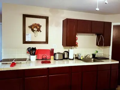 a kitchen with brown cabinets and a counter top at Charming Downstairs Unit in Oakhurst