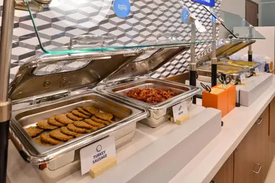 a buffet line with trays of food on a counter at Holiday Inn Express Reno Airport by IHG in Reno