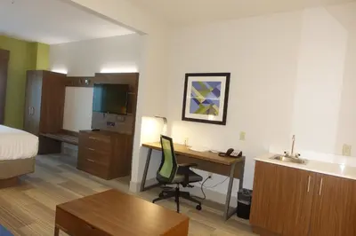 a hotel room with a desk and a bed at Holiday Inn Express & Suites Brentwood in Brentwood