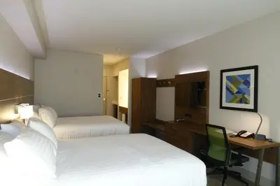 a hotel room with two beds and a desk at Holiday Inn Express & Suites Brentwood in Brentwood