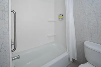 a white bathroom with a tub and a toilet at Holiday Inn Express Fresno South by IHG in Fresno