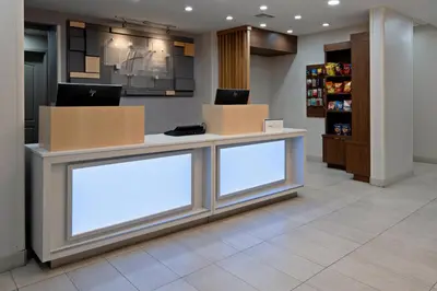 a lobby with two white signs on a counter at Holiday Inn Express Fresno South by IHG in Fresno