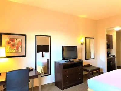 a hotel room with a bed and a desk with a television at Holiday Inn Express Fresno Northwest - Herndon by IHG in Herndon