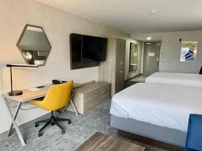 a hotel room with a bed and a desk with a computer at Holiday Inn Express Fresno Northwest - Herndon by IHG in Herndon