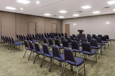 a conference room with blue chairs and a podium at Wyndham Garden Fresno Yosemite Airport in Fresno