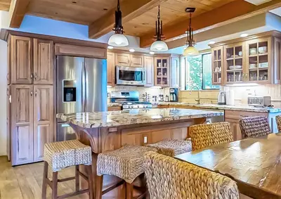 a kitchen with a large island with bar stools at Village Treehouse #1 in Mammoth Lakes