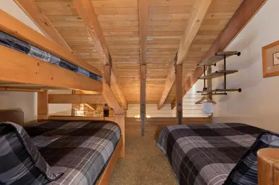 two bunk beds in a room with wooden ceilings at Village Treehouse #1 in Mammoth Lakes