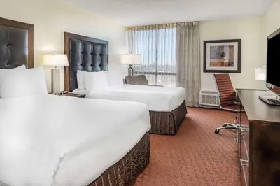 a hotel room with two beds and a television at Wyndham Sacramento in Sacramento