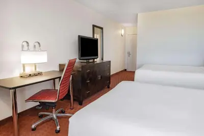 a hotel room with a bed and a desk with a television at Wyndham Sacramento in Sacramento