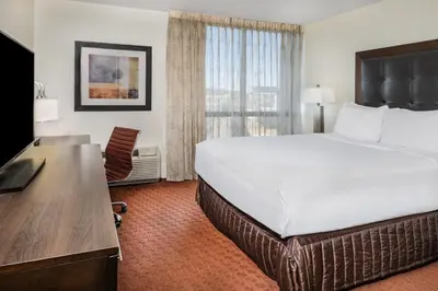 a hotel room with a large bed and a desk at Wyndham Sacramento in Sacramento