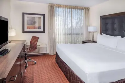 a hotel room with a large bed and a desk at Wyndham Sacramento in Sacramento
