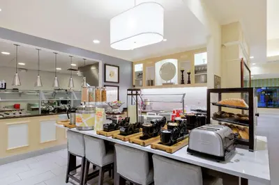 a kitchen with a counter with a breakfast bar at Hilton Garden Inn Sacramento Elk Grove in Elk Grove