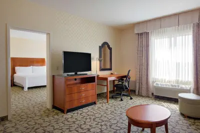 a hotel room with a television and a desk with a bed at Hilton Garden Inn Sacramento Elk Grove in Elk Grove