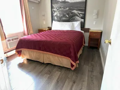 a bedroom with a bed with a purple comforter at Alpine Inn & Spa in South Lake Tahoe