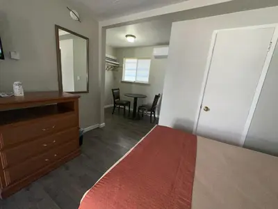 a bedroom with a bed and a dresser and a mirror at Alpine Inn & Spa in South Lake Tahoe