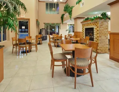 a restaurant with tables and chairs and a fireplace at Holiday Inn Express Hotel & Suites Carson City by IHG in Carson City