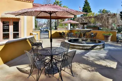 a patio with a table and chairs and an umbrella at Holiday Inn Rancho Cordova - Northeast Sacramento by IHG in Rancho Cordova