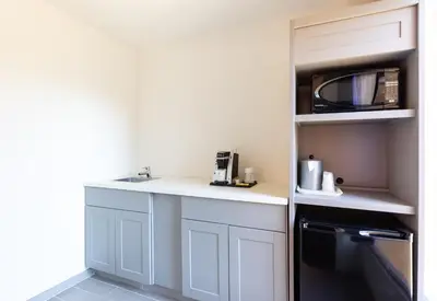 a small kitchen with a counter and a microwave at Holiday Inn Rancho Cordova - Northeast Sacramento by IHG in Rancho Cordova