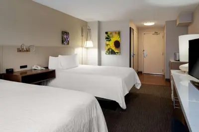 a hotel room with two beds and a television at Hilton Garden Inn Folsom in Folsom