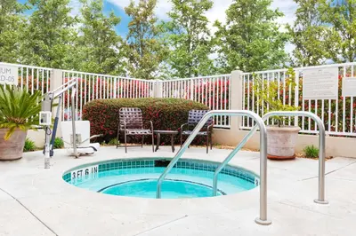 a hot tub in a patio with a fence at Hilton Garden Inn Folsom in Folsom