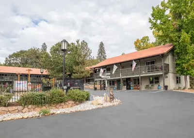 a building with a parking lot in front of it at Yosemite Westgate Lodge in Groveland