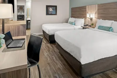 a hotel room with two beds and a desk with a laptop at Yosemite Westgate Lodge in Groveland