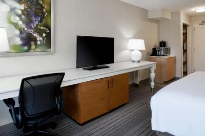 a hotel room with a desk with a monitor and a chair at Hilton Garden Inn Roseville in Roseville