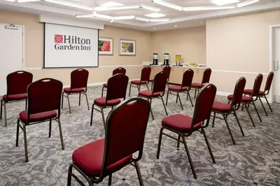 a conference room with red chairs and a podium at Hilton Garden Inn Roseville in Roseville