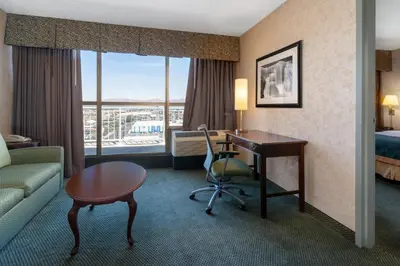 a hotel room with a desk and a room with a bed and a deskicter at Ramada by Wyndham Reno Hotel & Casino in Reno
