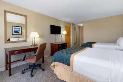 a hotel room with two beds and a desk and a bed at Ramada by Wyndham Reno Hotel & Casino in Reno