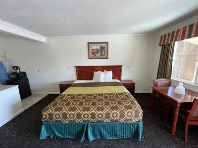 a hotel room with a bed and a desk at Americas Best Value Inn Hanford in Hanford