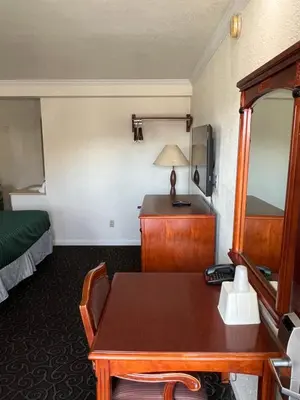 a hotel room with a table and a bed at Americas Best Value Inn Hanford in Hanford