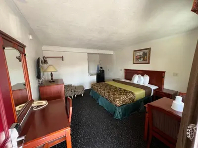 a hotel room with a bed and a desk at Americas Best Value Inn Hanford in Hanford