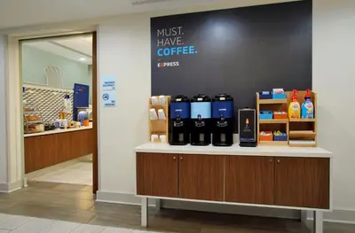a coffee shop with a counter with bottles of coffee at Holiday Inn Express Hotel & Suites Modesto-Salida by IHG in Modesto