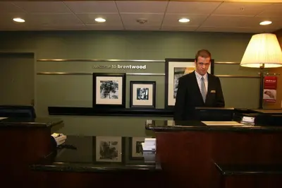 a man standing at a desk in a office at Hampton by Hilton in Brentwood