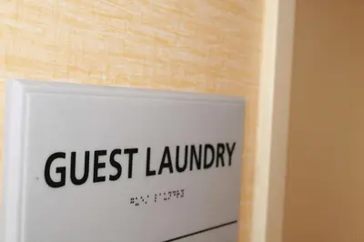 a sign that reads guest laundry on a wall at Hampton by Hilton in Brentwood