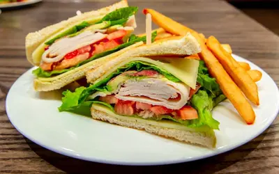 a sandwich and french fries on a white plate at Holiday Inn Auburn by IHG in Auburn