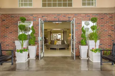 a lobby with a brick wall with potted plants at Holiday Inn Auburn by IHG in Auburn