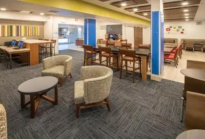 a waiting room with tables and chairs and a cafeteria at Holiday Inn Express Hotel & Suites Roseville - Galleria Area by IHG in Roseville