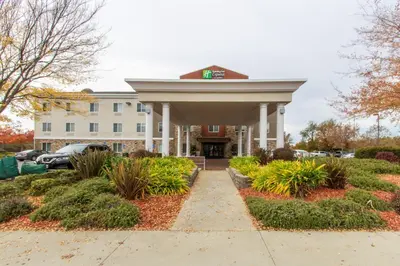 a large white building with a driveway in front at Holiday Inn Express Hotel & Suites Roseville - Galleria Area by IHG in Roseville