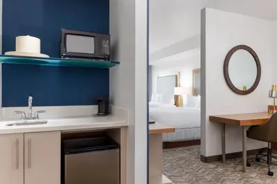 a bathroom with a sink and a room with a bed at SpringHill Suites by Marriott Sacramento Roseville in Roseville
