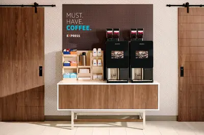 a coffee shop with a counter with a coffee maker on it at Holiday Inn Express Hotel & Suites Minden by IHG in Minden
