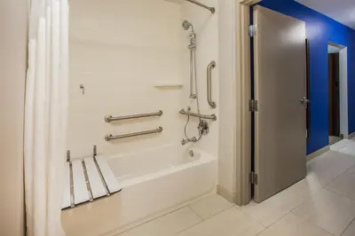a bathroom with a bath tub with a shower curtain at Holiday Inn Express Hotel & Suites El Dorado Hills by IHG in El Dorado Hills