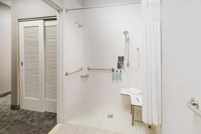 a white bathroom with a shower and a sink at Courtyard by Marriott Roseville in Roseville