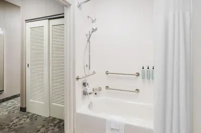 a white bathroom with a tub and a shower at Courtyard by Marriott Roseville in Roseville