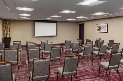 a conference room with chairs and a white screen at Courtyard by Marriott Roseville in Roseville