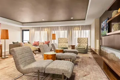 a living room with couches and chairs and a tv at Courtyard by Marriott Roseville in Roseville