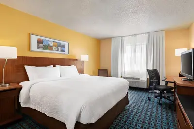 a hotel room with a bed and a desk and a television at Fairfield Inn by Marriott Roseville in Roseville
