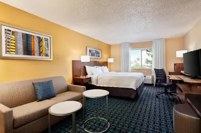 a hotel room with a bed and a couch at Fairfield Inn by Marriott Roseville in Roseville